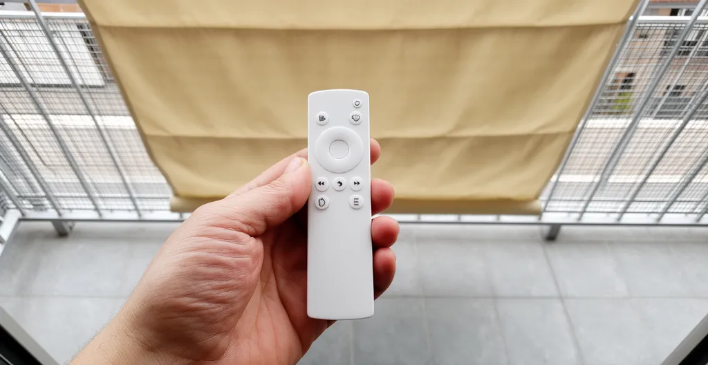 Mano con mando a distancia controlando toldo monobloc motorizado